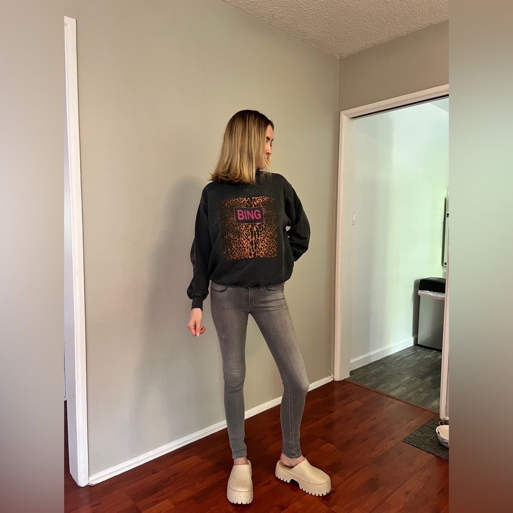 Black Anine Bing pullover with cheetah print detail and hot pink lettering.